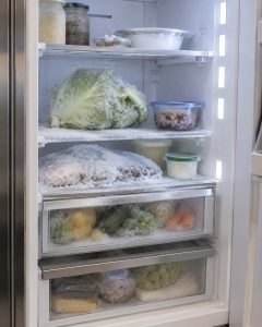 Sub-Zero built-in refrigerator with frozen lettuce and ice-crusted food in the fresh-food section